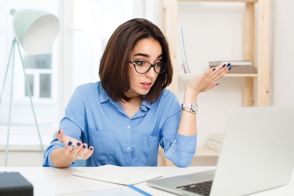 A confused female business owner looking at her laptop screen