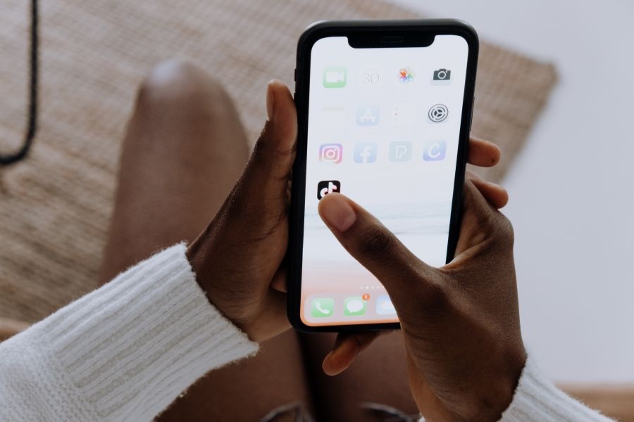 a-hand-holding-a-phone-showing-different-social-media-apps.jpg
