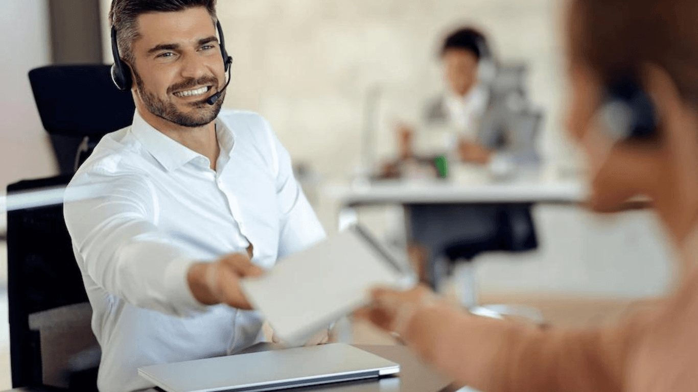 A call center agent guy receiving a report from a colleague
