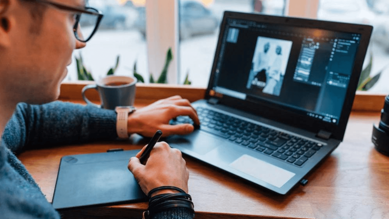 man is editing photos laptop using graphics tablet interactive pen display