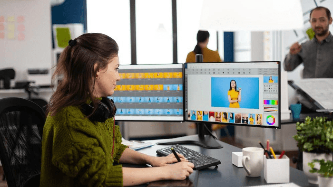 A graphic designer performing photo retouching on her desktop computer