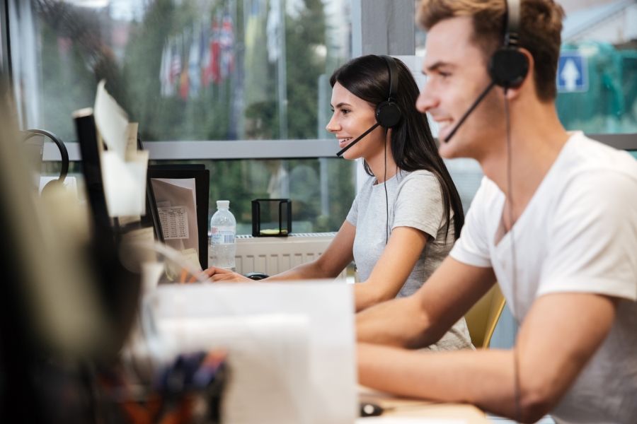 side-view-of-coworkers-in-white-t-shirts-sit-by-the-table-in-headphones-call-center.jpg